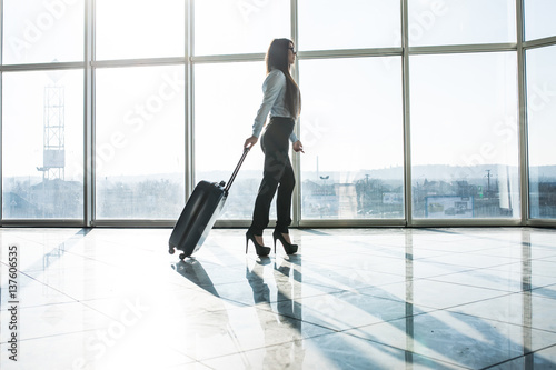 Business woman walking with baggage in airport