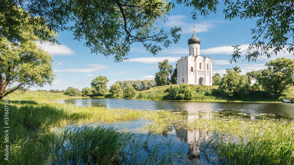 Church of the Intercession on the Nerl. Ancient white Russian church reflected in the lake. Classic Russian summer province landscape. Peaceful tranquil place for soul. Famous touristic landmark. Church of the Intercession on the Nerl. Ancient white Russian church reflected in the lake. Classic Russian summer province landscape. Peaceful tranquil place for soul. Famous touristic landmark.