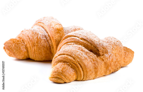 two croissant sprinkled with powdered sugar isolated on a white background closeup