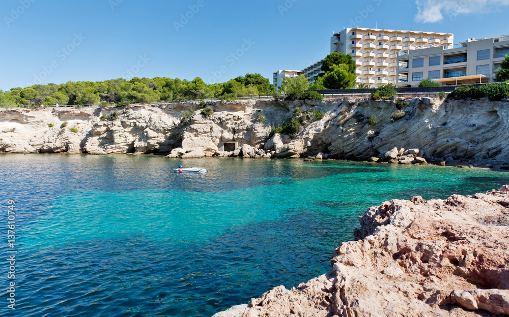 Beautiful turquoise bay at Ibiza. Hotel on the beach. Luxury rest at Balearic Islands. Beautiful place for diving. Holidays in the Mediterranean.