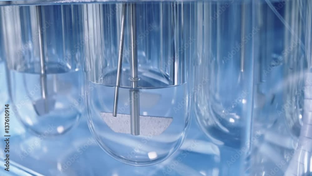 Experiments at the Lab. Sliding Shot of a Dissolution Apparatus Testing Medication Pills Dissolving Tablets in Liquid.Laboratory Routine.