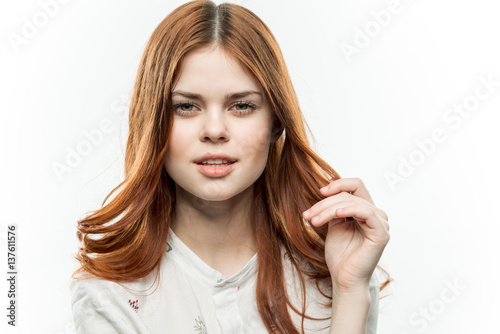 beautiful red-haired woman on a light background