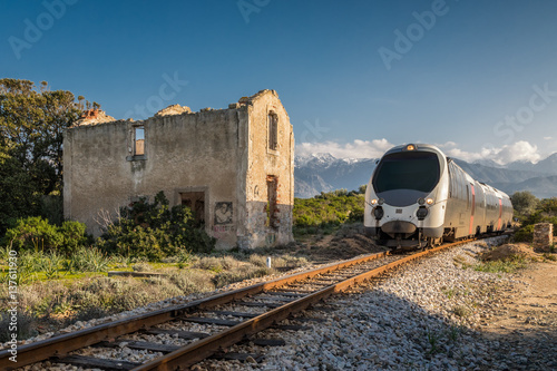 Train passing derelict station at Lumio in Corsica