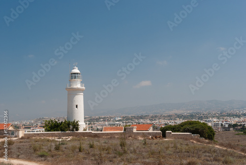 White lighthouse and road on deserted seashore near Paphos city, Cyprus