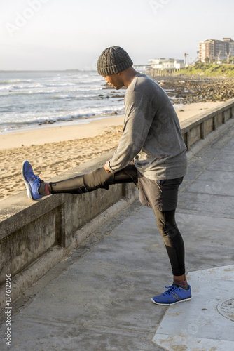 Jogger Stretching on Promonade by beach photo