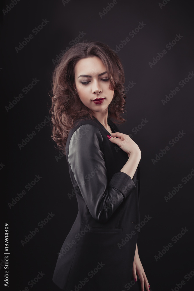 Brunette young woman with lush curly hair in black jacket Brunette young woman with lush curly hair in black jacket