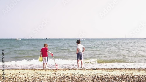 Two boys playing on the beach in Southend on Sea, Essex photo