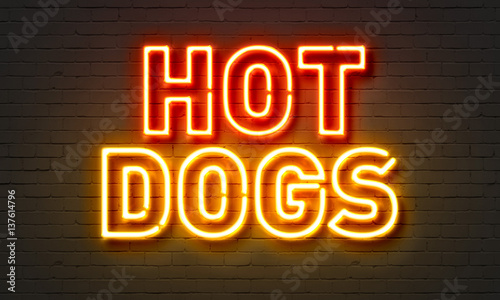 Hot dogs neon sign on brick wall background.