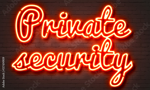 Private security neon sign on brick wall background.