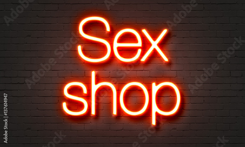 Sex shop neon sign on brick wall background. photo