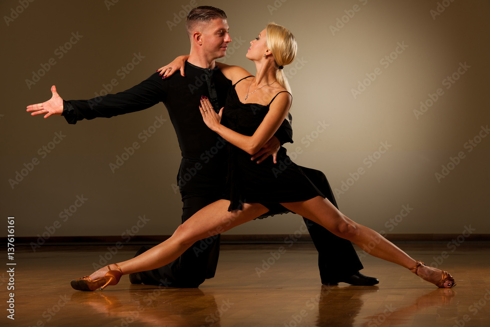 Beautiful ballroom couple preforming their pasonate exhibition dance - obrazy, fototapety, plakaty 