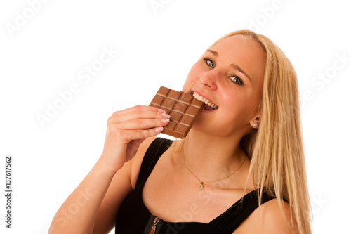 Beautiful young woman eats chocolate isolated over white background