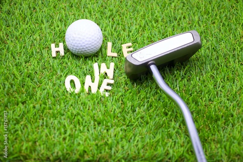 Foto Hole in one word with golf ball and putter