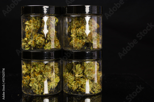 4 stacked quarter ounce jars of marijuana cannabis