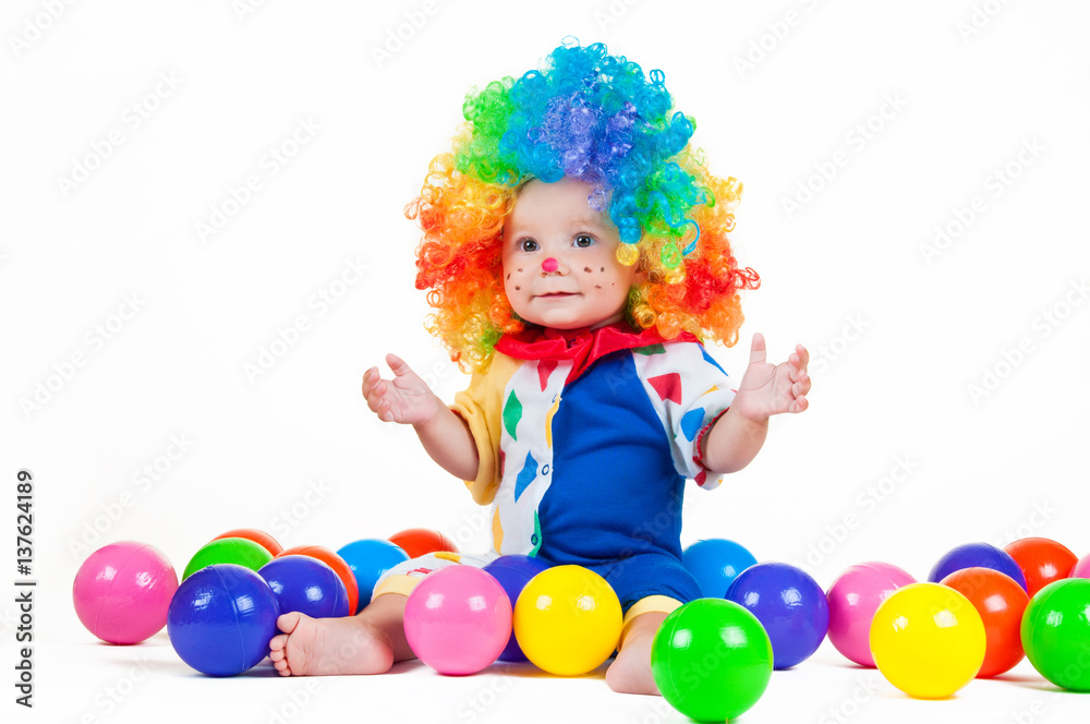 Child clown with a red nose multicolored wig in with balls Child clown with a red nose multicolored wig in with balls