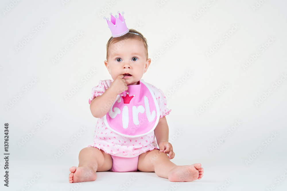 Girl with a crown, sitting in a bib on a white background.
