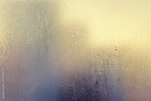 Sunny foggy window glass blurry condensation background, closeup image