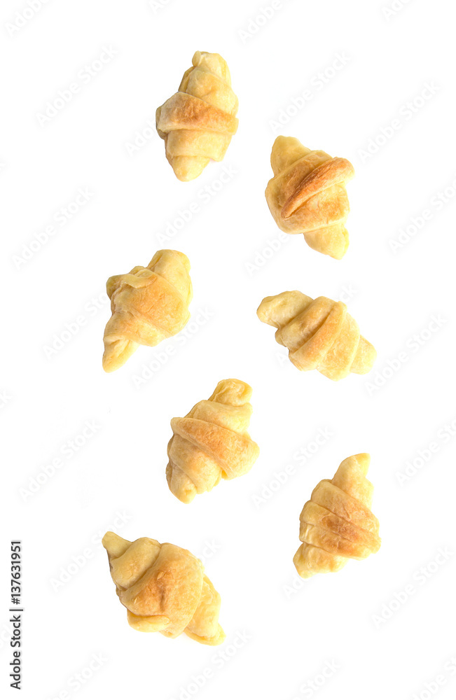 Falling mini croissants on white background.