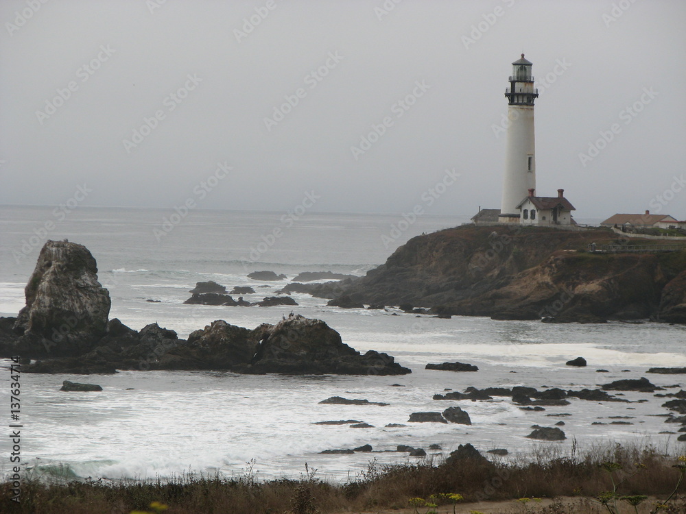 lighthouse and large rocks in ocean