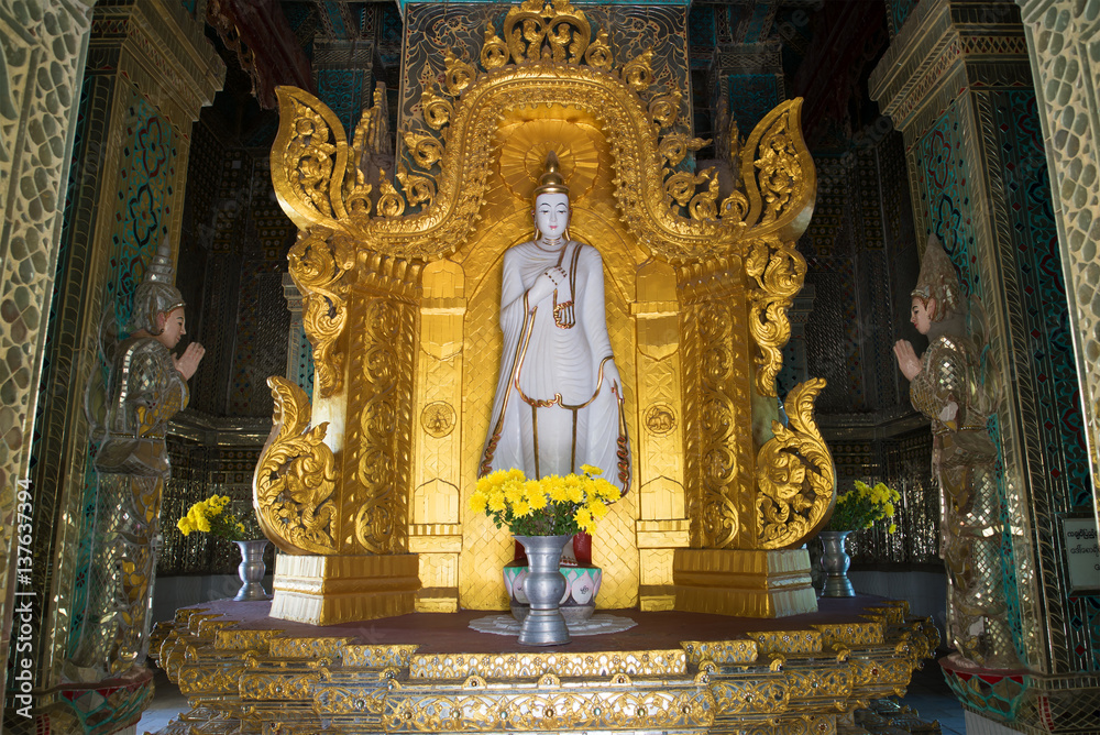 The sculpture of standing Buddha in the interior of the stupa Mahar Gandar Yone monastery. Myanmar