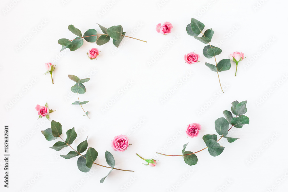 Flowers composition. Frame with rose flowers and eucalyptus branches. Flat lay, top view Flowers composition. Frame with rose flowers and eucalyptus branches. Flat lay, top view