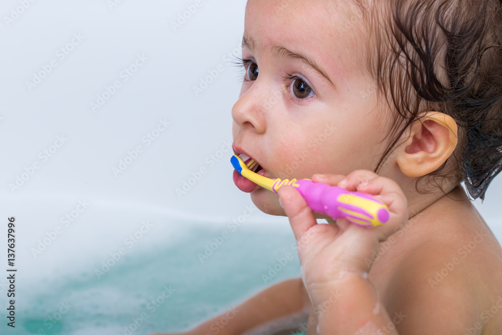 cute little girl bathes in a bath and brushing his teeth, the concept of hygiene and cleanliness cute little girl bathes in a bath and brushing his teeth, the concept of hygiene and cleanliness