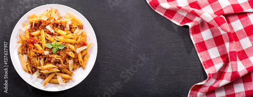 plate of pasta bolognese on dark table
