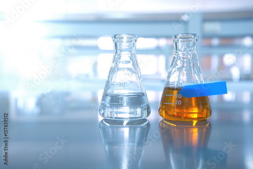 two flask with water and orange solution with blue label in science