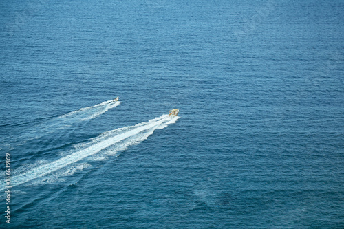 Two speed motor boats or ships travel by sea