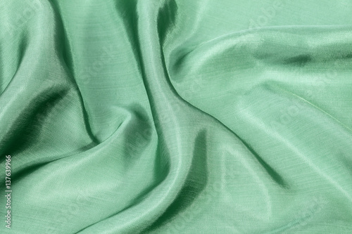 Silk background, texture of green  shiny fabric