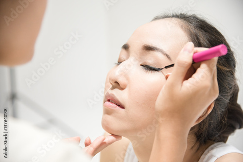 Make up artist applying make up to a clean face fashion model or bride