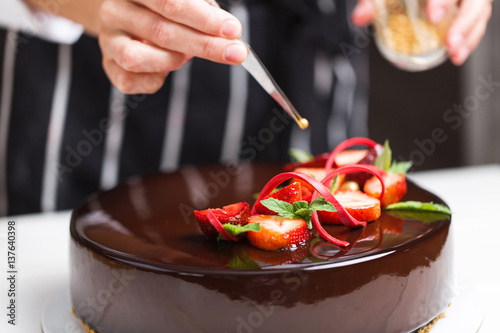 Female hands decorating cake photo