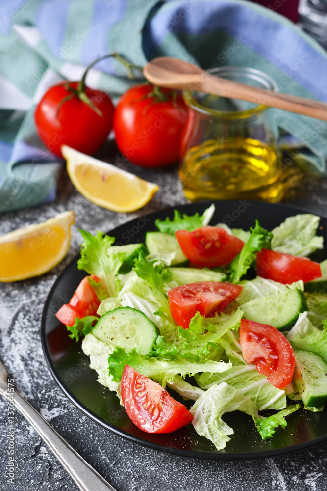 Vegetable salad with cucumber, tomatoes and olive oil on a concrete background