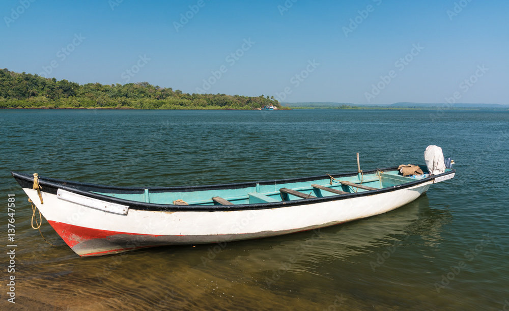 the river, the boat at the coast, the blue sky, the horizon