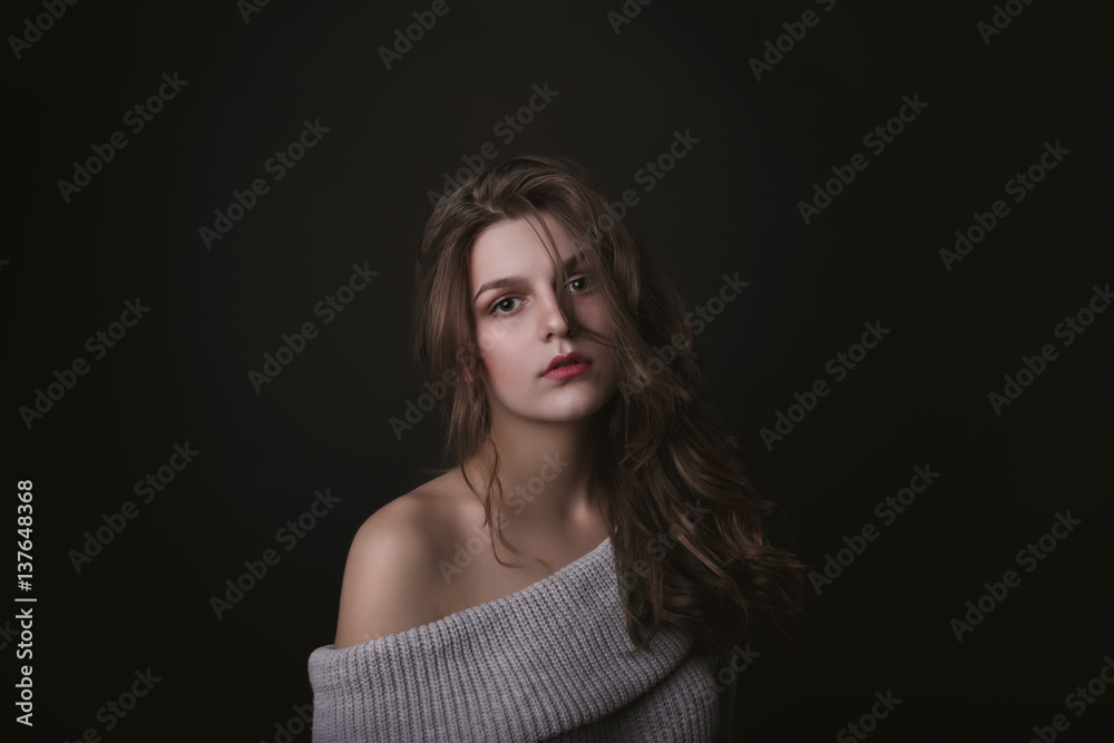 Tender young woman with naked shoulders in the dark Tender young woman with naked shoulders in the dark