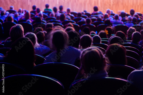 People, children, adults, parents in the theater watching the performance.