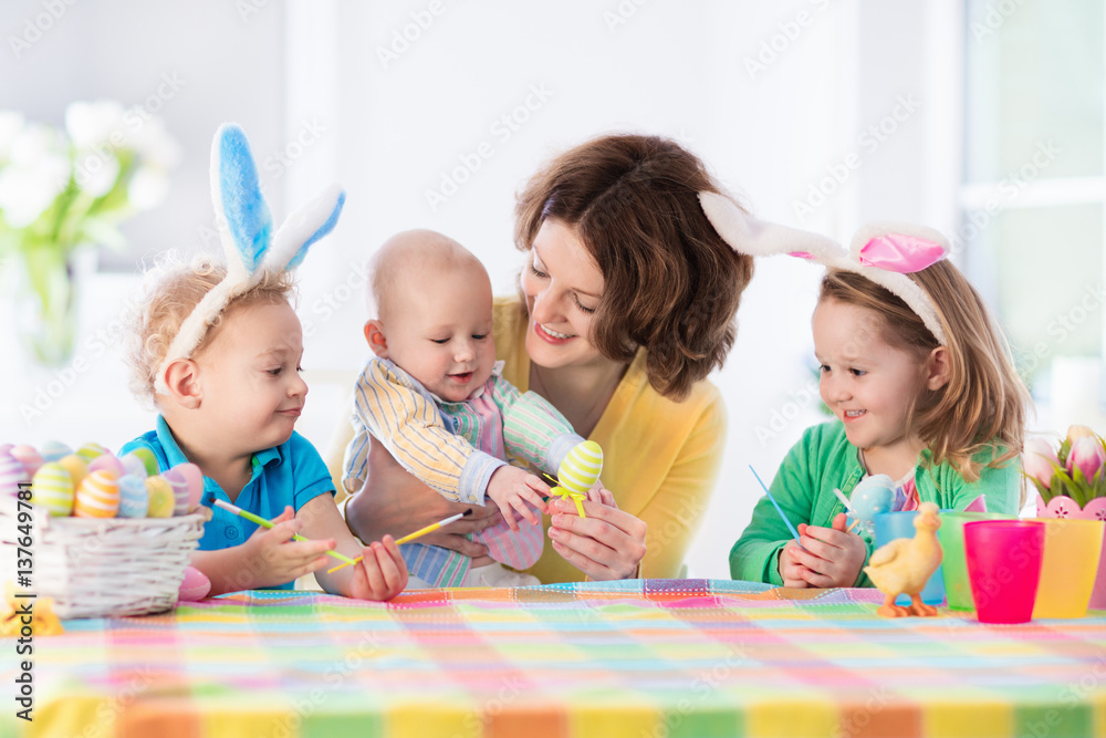 Mother with three children painting Easter eggs Mother with three children painting Easter eggs