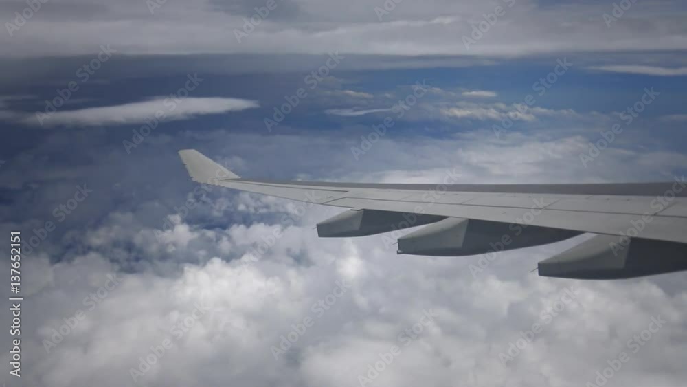 4K Traveling by air. Aerial view with many clouds in the Sky and the ocean from above, as seen through an airplane window-Dan