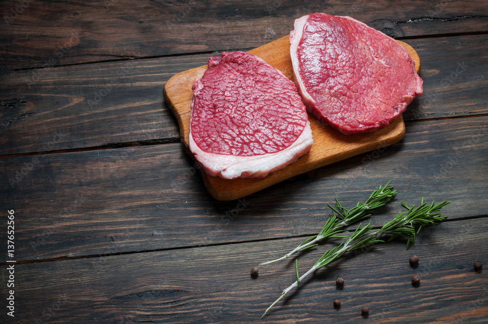 Fresh raw beef steak and chilli pepper on wood