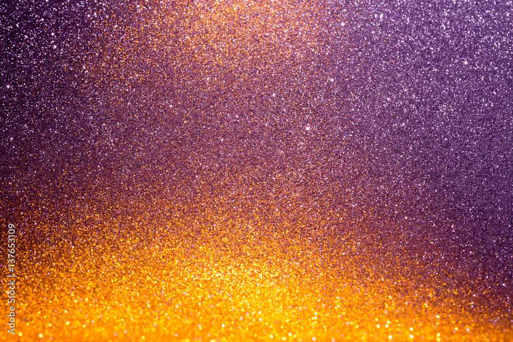 Abstract background filled with shiny gold and purple glitter