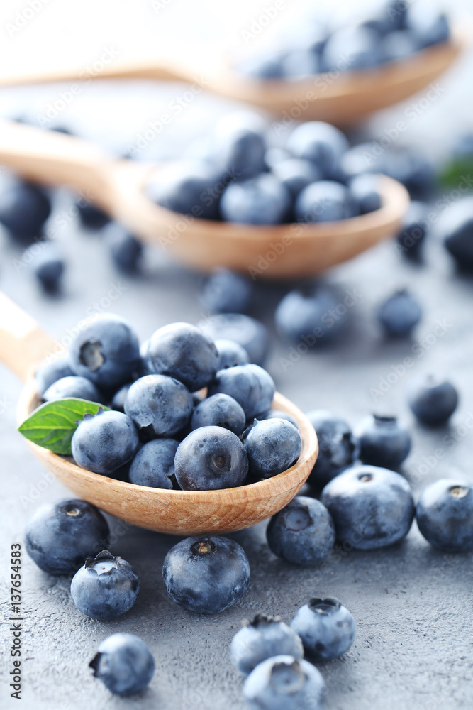Ripe and tasty blueberries on grey wooden table Ripe and tasty blueberries on grey wooden table