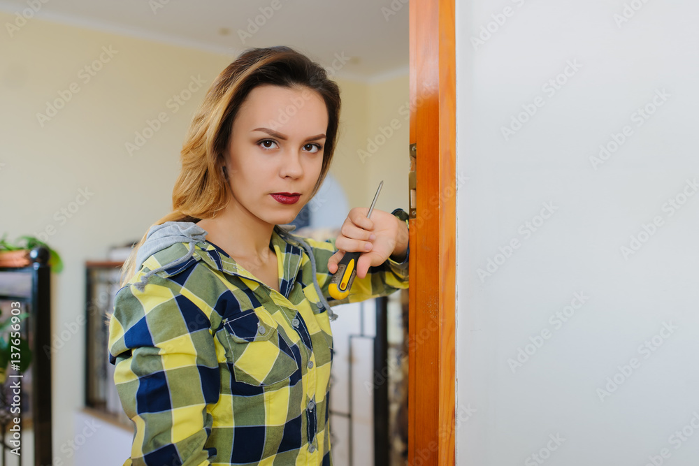 woman builder working using a screwdriver and fix the door woman builder working using a screwdriver and fix the door