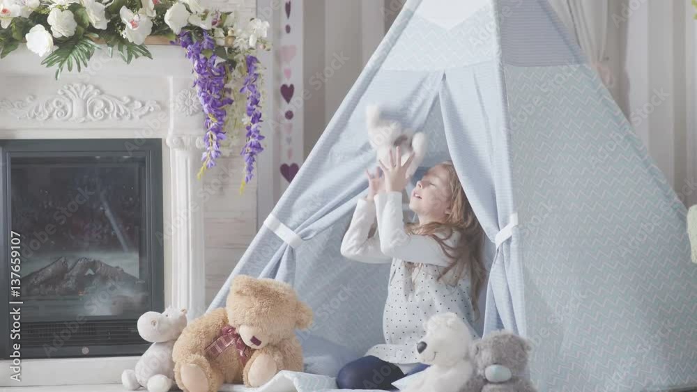 Vidéo Stock Girl throws up teddy white bunny. Girl playing with a toy