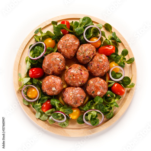 Raw meatballs on cutting board on white background