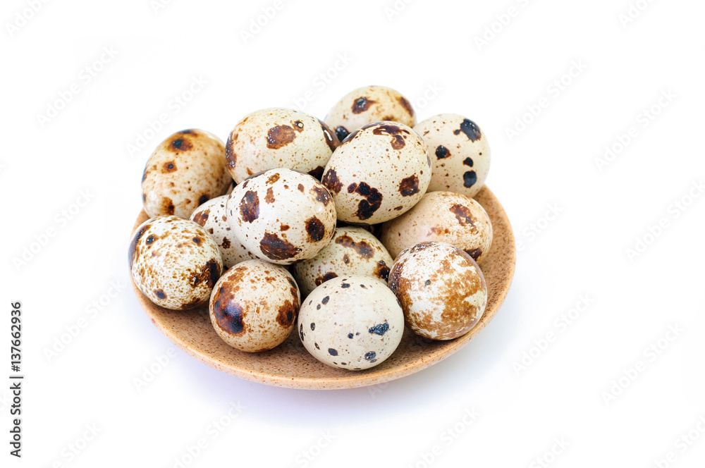 quail eggs on a brown plate isolated on white backdrop