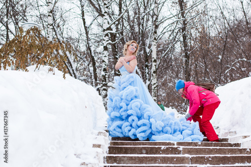 Preparation for shooting of woman in blue dress in the park in a winter