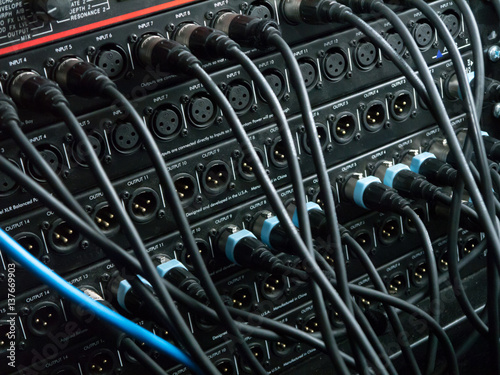 XLR cables plugged into different inputs and outputs at a recording studio photo