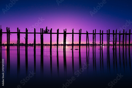 Silhouetted person with a bike on U Bein Bridge at night Amarapura, Mandalay region, Myanmar