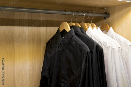 wooden clothes rack with white and black shirts