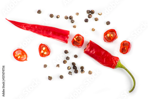 rote Peperoni und Pfefferkörner auf weiß photo